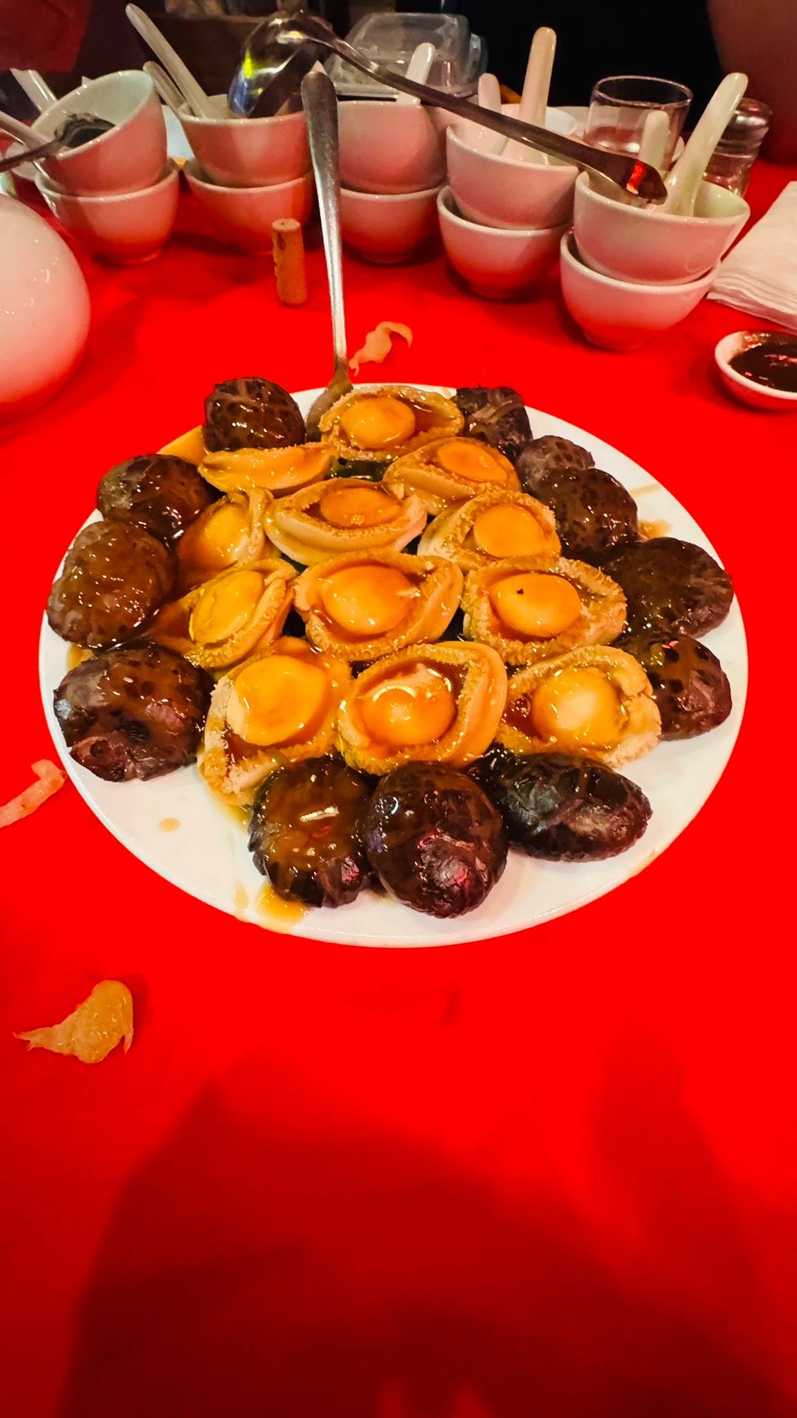 Sliced abalone arranged over mushrooms