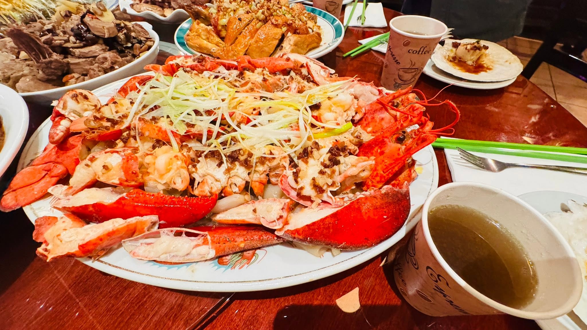 A whole lobster dish with vegetables and garnish