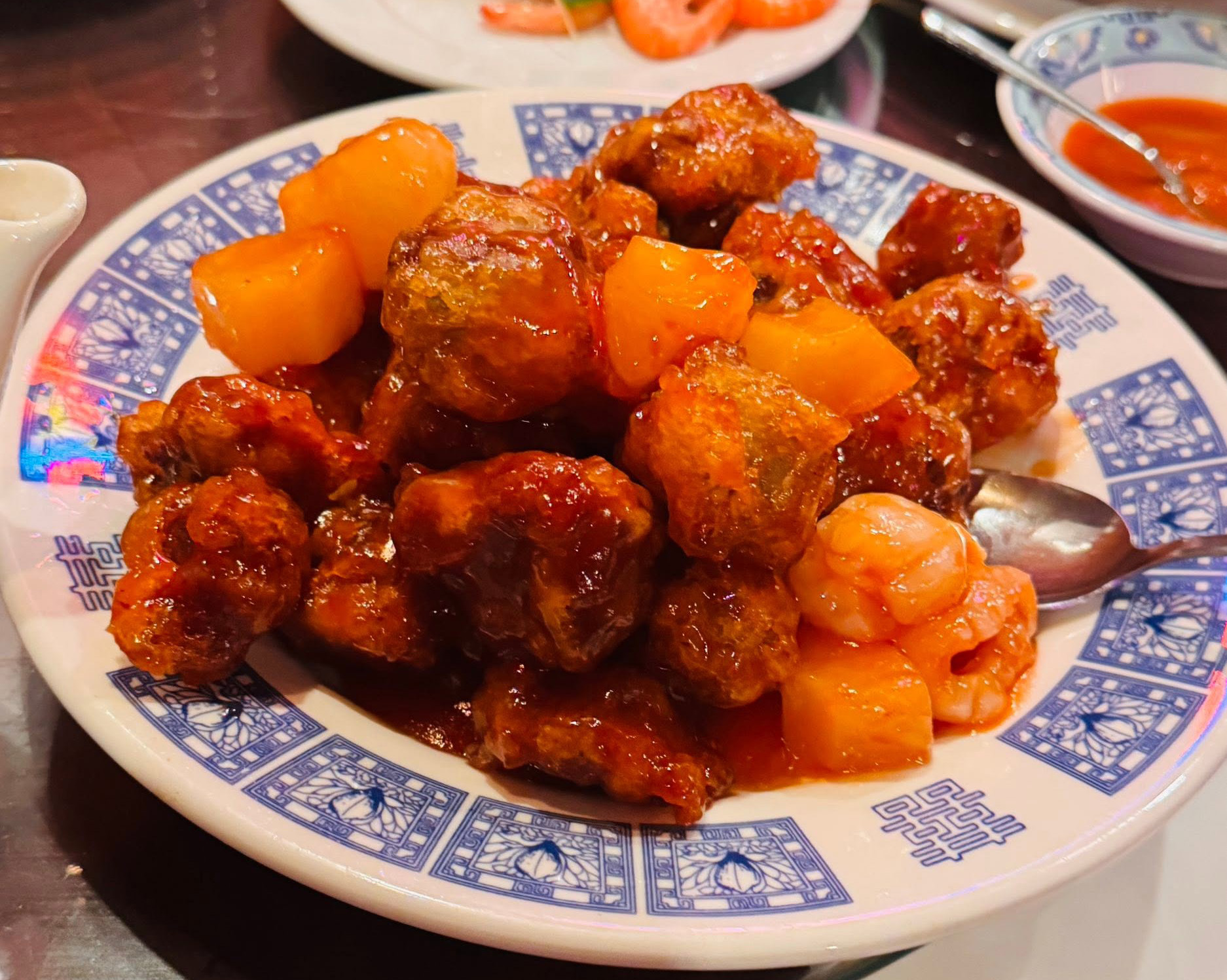A plate of glazed sweet and sour pork ribs with fruit