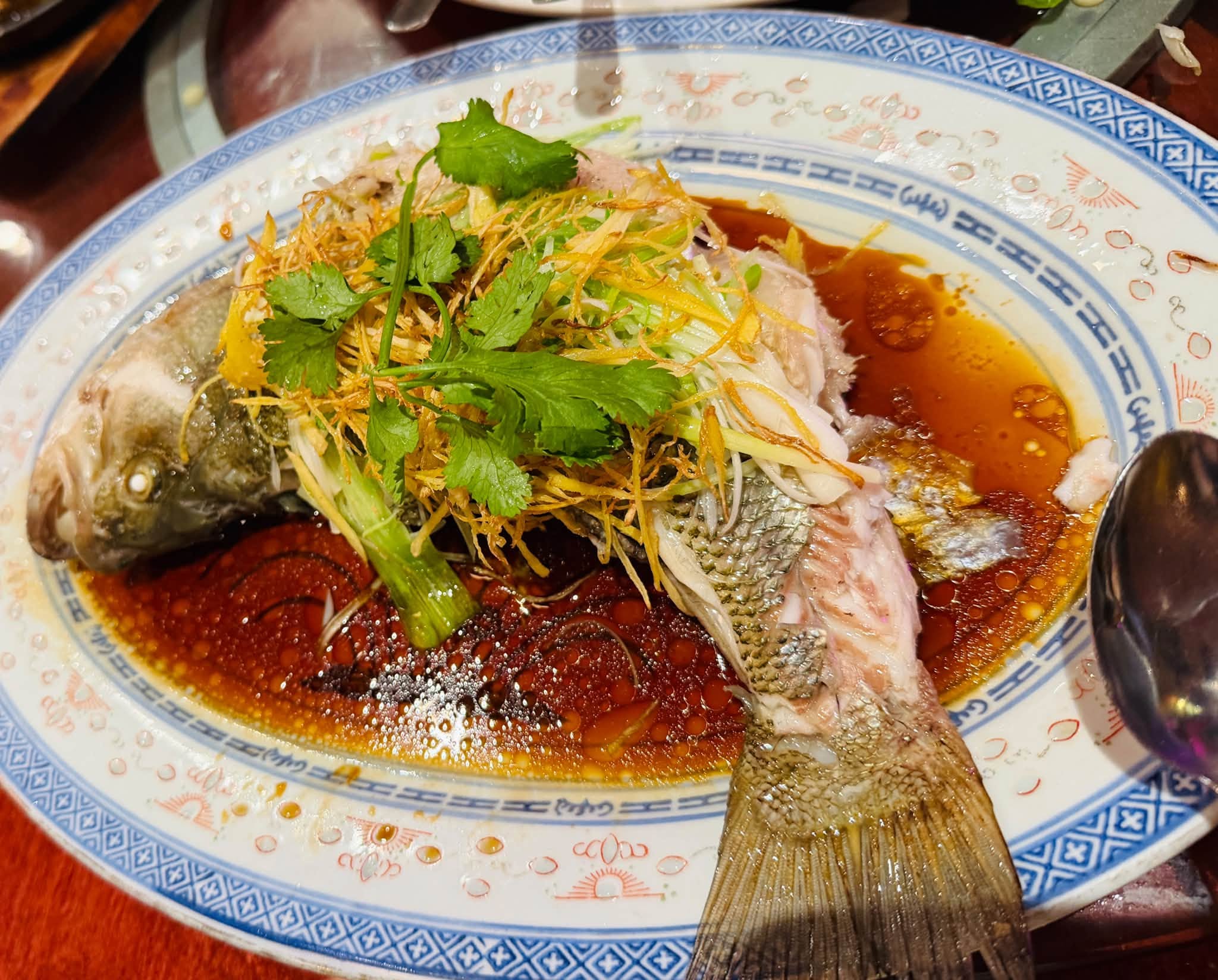 A whole steamed fish with ginger and herbs