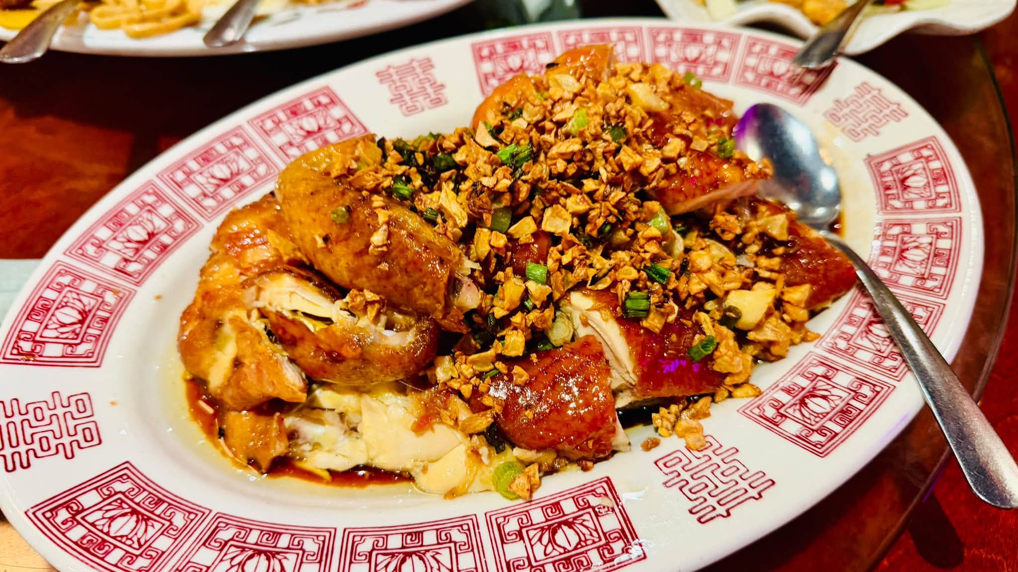 A plated chicken dish with rice and toppings